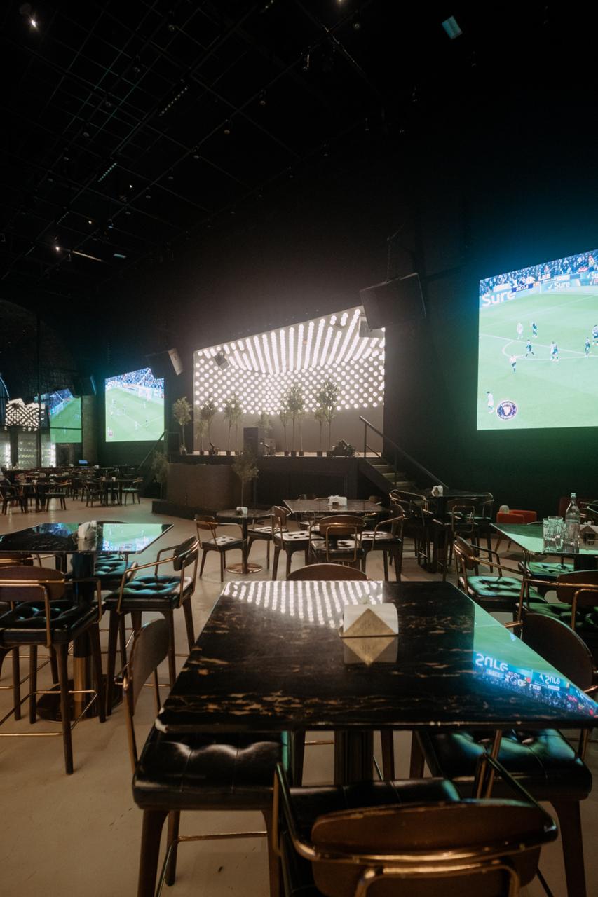 Sports lounge with multiple screens and modern seating